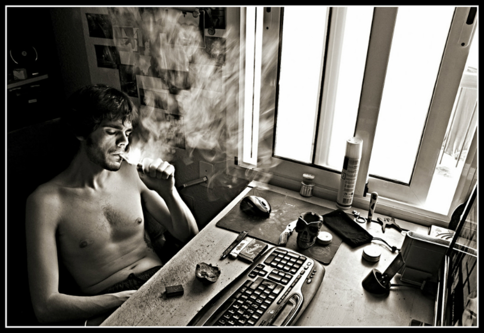 man smoking joint at computer