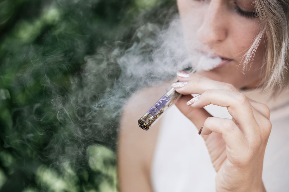 Woman smoking weed in glass pipe