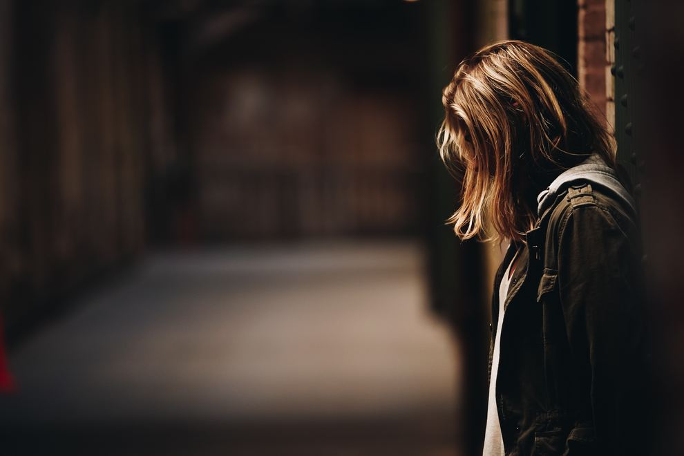 Girl leaning on wall face hidden