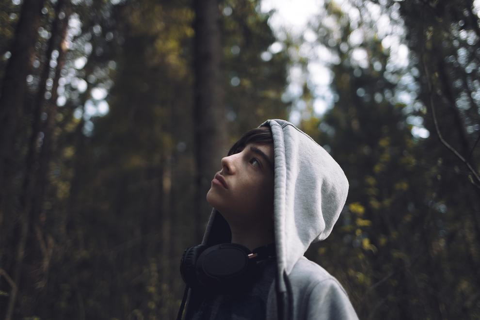 Young Man Looking up at trees