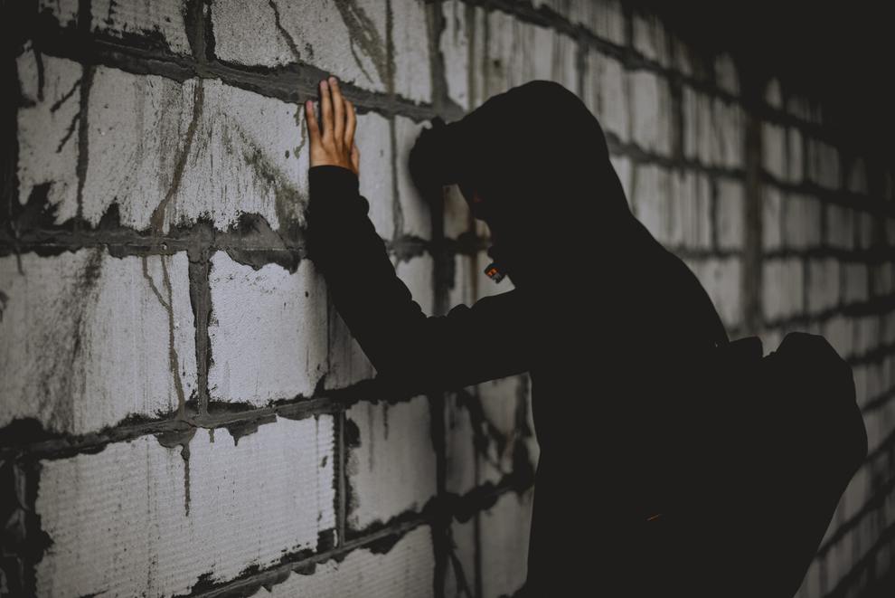 B&W man facing wall