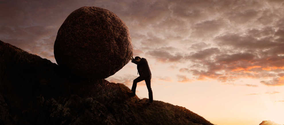 uphill battle pushing boulder up hill