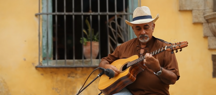 man wearing hat playing guitar