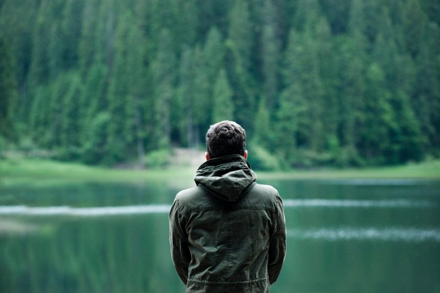 young man sitting by lake